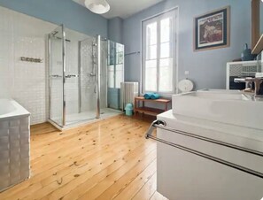 A bathroom with a glass shower, a bathtub, and a toilet.
