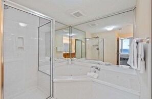 A bathroom with a glass-enclosed shower, a large mirror, and a bathtub. - Inn at Summerwind 1101 | Beachfront Corner Condo | Outdoor Pool | Fitness Center | My Beach Getaways (Navarre)