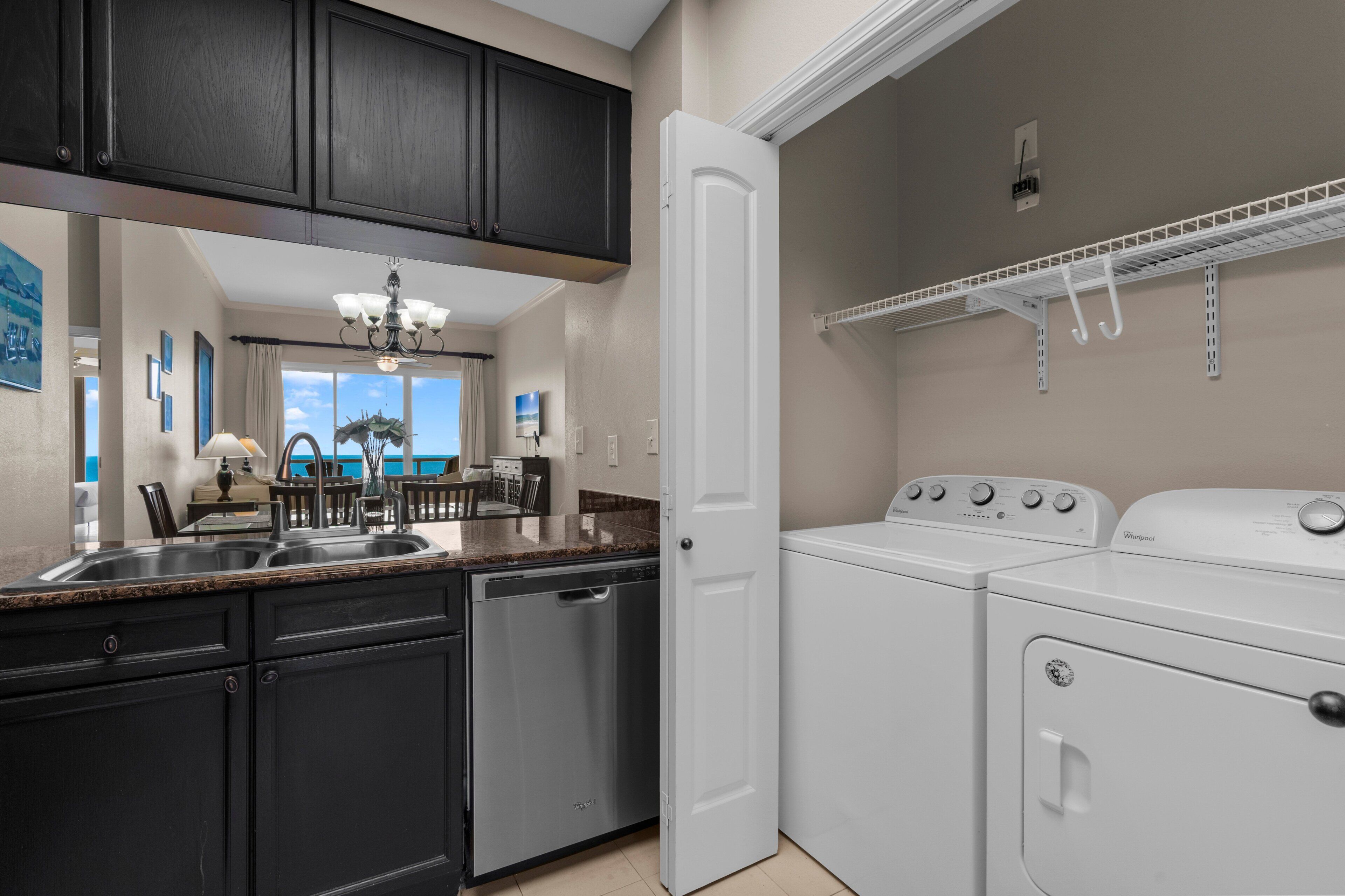 A kitchen with a dishwasher, a built-in oven, and a countertop with a sink.