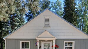 A single-story building with a gabled roof, a front porch, and a number '205' on the door. - Cottage with kitchen, walking distance to airport, restaurants, historical sites (Idaho City)