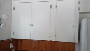 A kitchen with white cabinets, a wooden countertop, a sink, and a white refrigerator. - Cottage with kitchen, walking distance to airport, restaurants, historical sites (Idaho City)