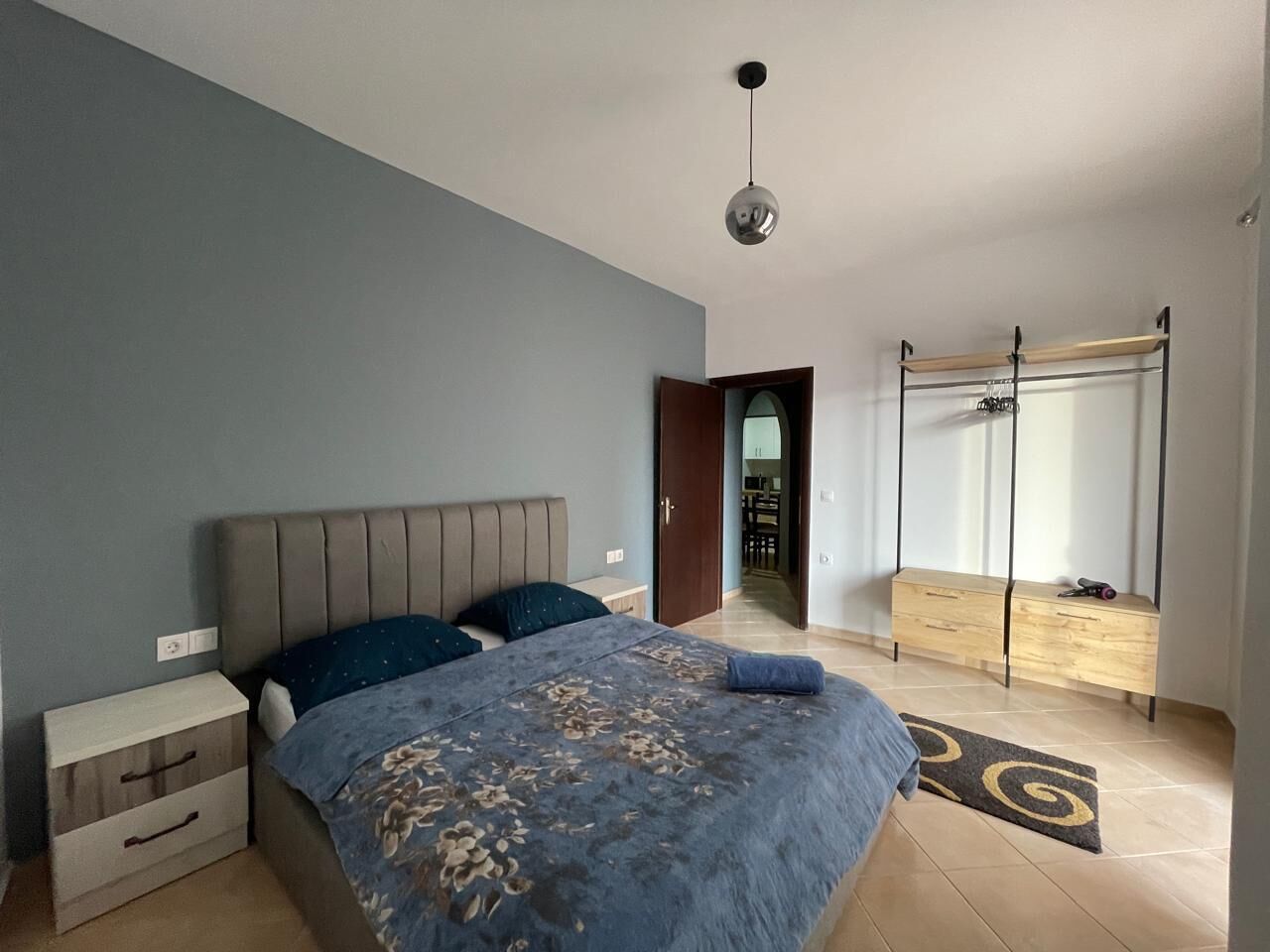 A bedroom with a bed, bedside table, and a wardrobe.