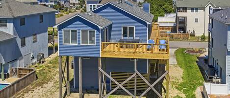A beachfront house with a raised deck and a small pool.