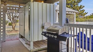 Ein überdachter Außenbereich mit Grill und einer mobilen Toilette.