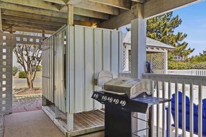 A covered outdoor area with a grill and a portable toilet. - Salty Crab | 1,200 ft to the beach | Private Pool, Hot Tub, Dog Friendly, and Community Pool (Corolla)