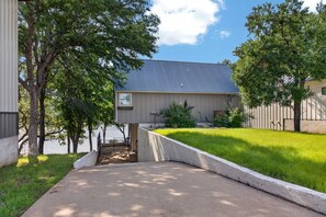 Il s’agit d’une propriété résidentielle dotée d’une allée pavée, d’une pelouse et d’une maison avec un toit gris.