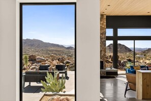 Un interior moderno con un amplio ventanal que da a un paisaje desértico.