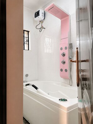 A modern bathroom with a white bathtub, a pink showerhead, and a handheld shower attachment.
