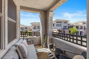 A balcony with a sofa, a chair, and a cactus plant. - Aeris - Pool & Gym - Near Kierland Commons (Scottsdale)