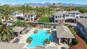A residential area with a swimming pool, palm trees, and houses with a mountain backdrop. - Aeris - Pool & Gym - Near Kierland Commons (Scottsdale)