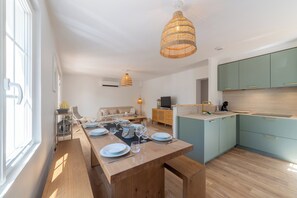 Eine moderne Küche mit Essbereich, Holzboden und hellblauen Schränken.