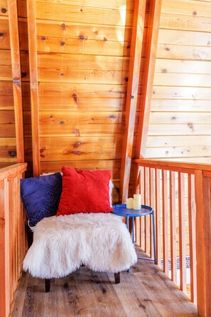 A wooden cabin interior with a bed, a small table, and a fur throw. - New! Bearadise ~Cozy Modern Getaway ~A-Frame Cabin (Big Bear)