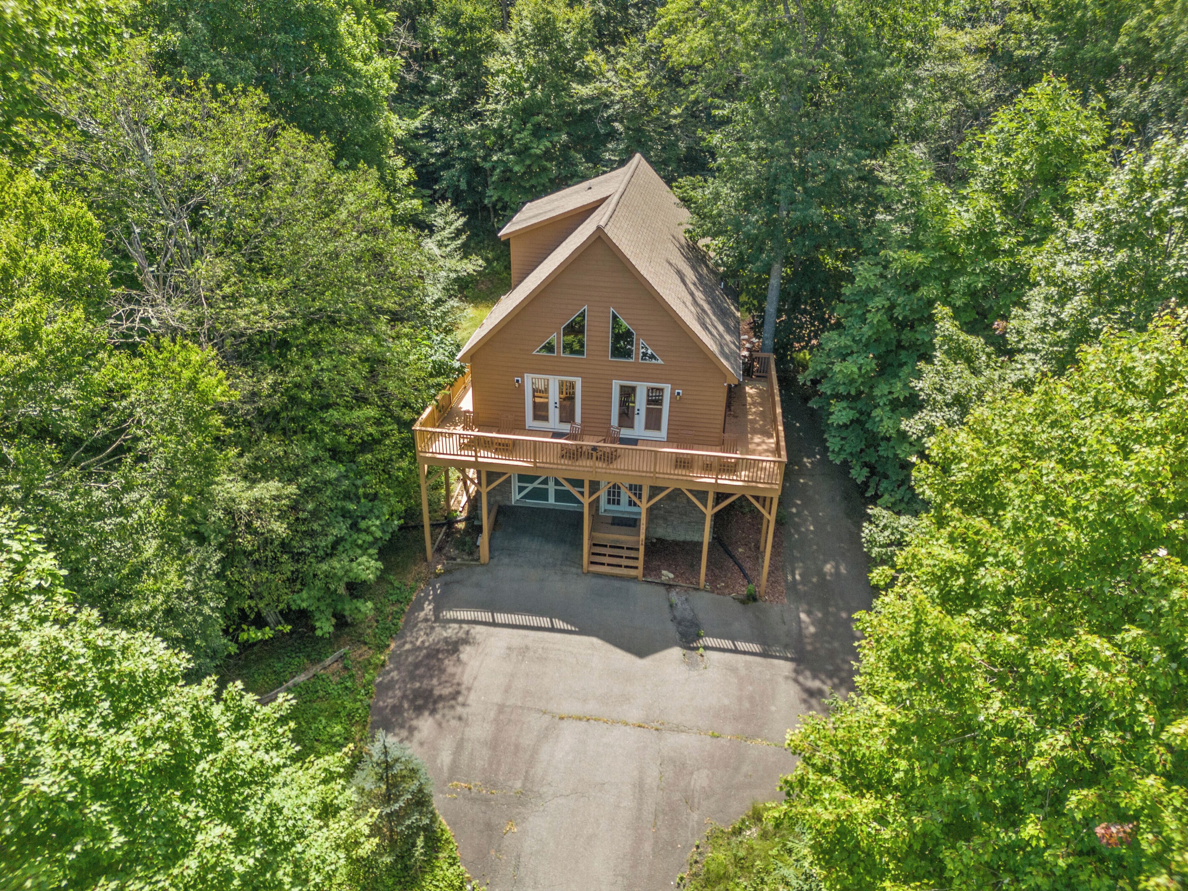 Une cabane en bois dotée d’un balcon, entourée d’une forêt dense.