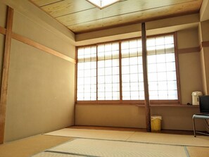A traditional Japanese room with tatami flooring, shoji sliding doors, and a wooden ceiling. - Onsen Ryokan Hirosuke (Fukushima)