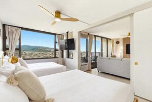 Ein Hotelzimmer mit zwei Betten, einem Fernseher und einem Balkon mit Blick.