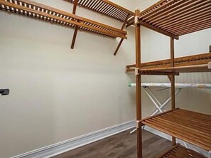 A room with a wooden shelving unit against the wall, a metal ladder, and a white curtain. - Still Waters hosted by Beach Retreats FL (Holmes Beach)