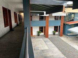 A building with a covered outdoor area, multiple doors, and a staircase.