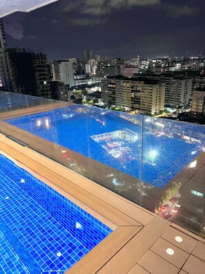 Ein Dachpool mit Blick auf die nächtliche Skyline.