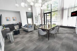 Et moderne interiør med spiseområde, køkken og store vinduer.