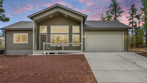 Ein zweistöckiges Haus mit Garage, überdachter Veranda und einem gepflegten Rasen.