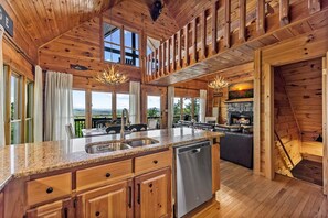 Ein Holzhaus-Interieur mit Küche, Essbereich und Kamin.