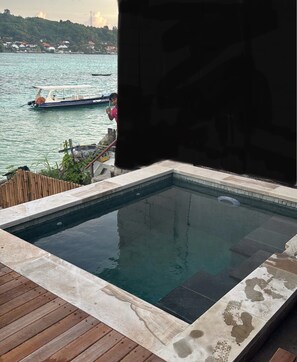Una piscina con muelle de madera y vista al agua.