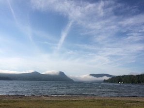 A lake with mountains in the background and a clear sky.