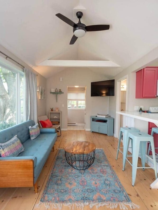 A modern living space with a sofa, coffee table, and bar stools.
