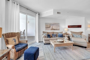 A living room with a sofa, armchair, coffee table, and a painting on the wall. - Dunes of Seagrove 302B - Gulf front with great views! (Santa Rosa Beach)