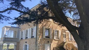 Ein Gebäude aus Stein mit einer Treppe, einem Balkon und einem Tisch mit Stühlen im Innenhof.