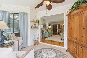 A living room with a ceiling fan, a sofa, a coffee table, and a wooden cabinet.