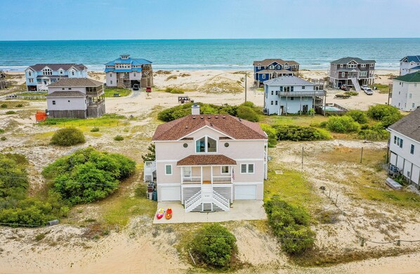A beachfront property with multiple houses, a sandy beach, and the ocean in the background. - Ocean Aire - 4x4 Carova Beach, Ocean View, Hot Tub, Large Decks, Pets OK, Kayaks (Carova Beach)