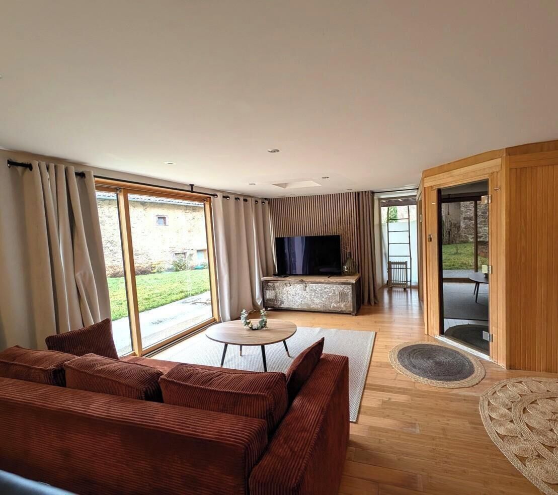 A modern living room with a sofa, TV, and a small table.
