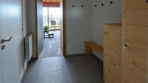 En gang med en træbænk, en radiator og et træskab.