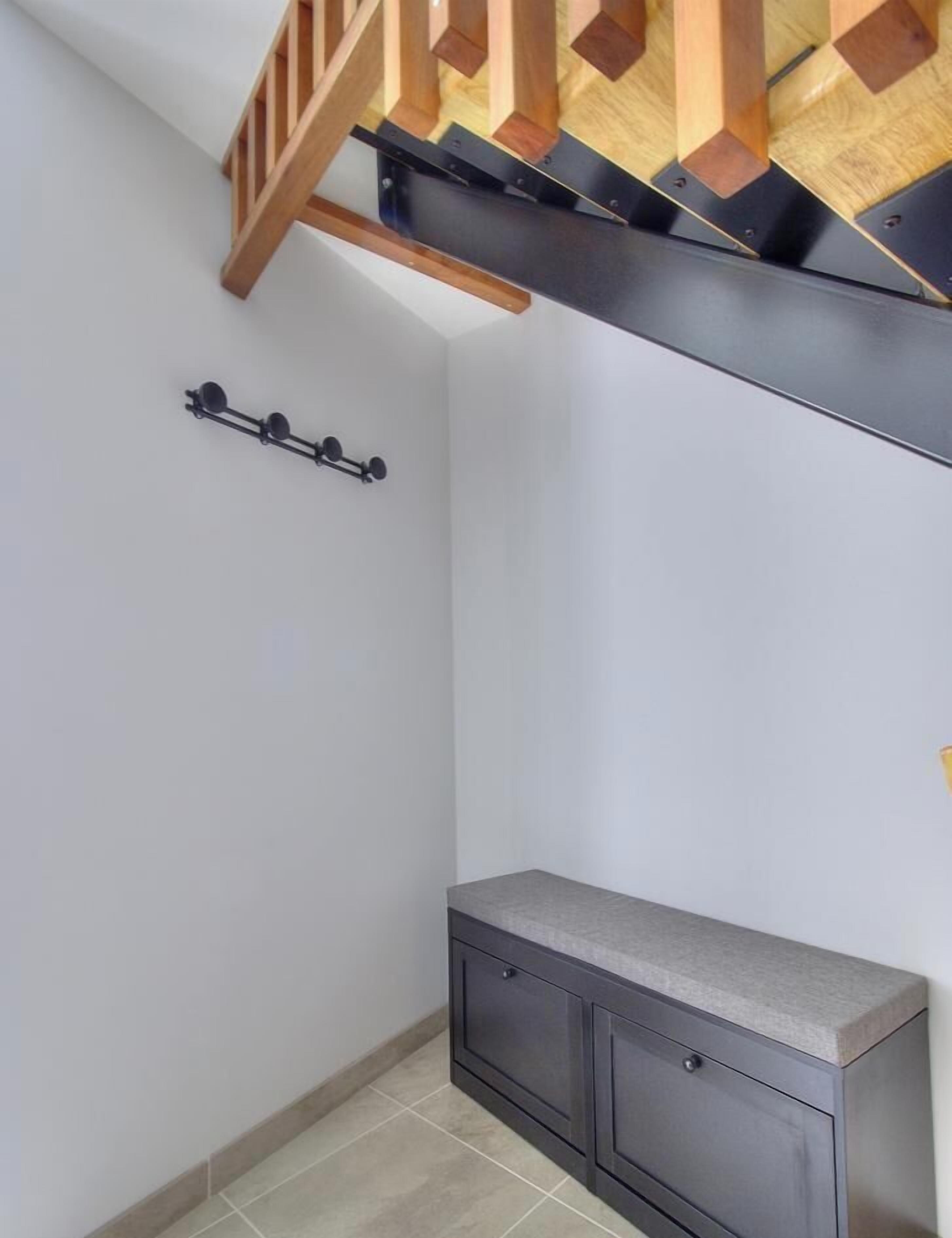 Une pièce avec un plafond en bois, un meuble gris et un luminaire fixé au mur.