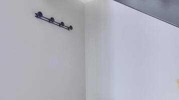 Une pièce avec un plafond en bois, un meuble gris et un luminaire fixé au mur.