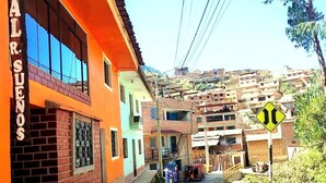 A street view with a building labeled 'HOSTAL AL R. SUEÑOS' and a sign indicating a two-way street ahead. - THE SHELTER OF MY DREAMS (Yungay)