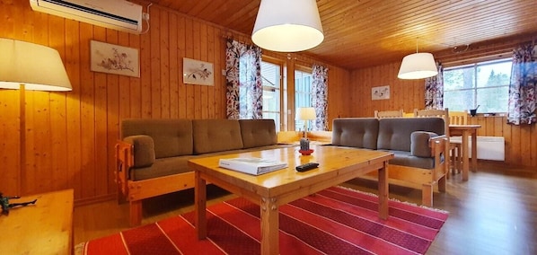 Ein Holzinnenraum mit einer Couch, einem Tisch und einer Lampe.