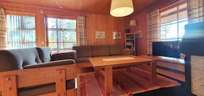 Ein Holzinnenraum mit einer Couch, einem Tisch und einem Fernseher.