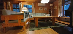 A wooden interior with a sofa, a table, and a television.