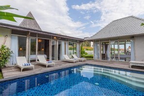 Ein Poolbereich mit Liegestühlen und freiem Blick auf das Schwimmbecken.