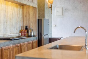 Eine Küche mit Holzausstattung, einem Edelstahlkühlschrank und einer Spüle.