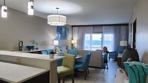 Een moderne woonkamer met een keukenhoek, een eettafel en uitzicht op de oceaan.