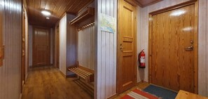 Ein Flur mit Holzdielen, einer Bank, einer Tür mit einer Karte und einem Feuerlöscher.