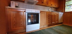 Eine Küche mit Holzausstattung, einem weißen Backofen und einem Geschirrspüler.