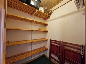 Ein Zimmer mit Holzböden, einem Bett mit einem Holz-Kopfteil und einem Wandlüfter.