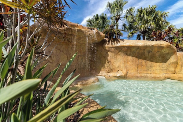 Eine natürliche Felsformation mit einem klaren Pool und einem Wasserfall.