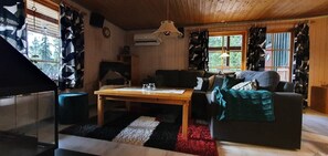 Ein gemütliches Wohnzimmer mit einer Couch, einem Couchtisch und einer Treppe.