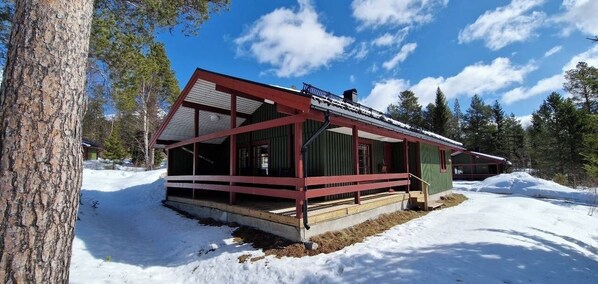 A cabin with a covered porch, a chimney, and a snow-covered ground. - Sauna | Wi-Fi | Terrace | Wood stove | Cable TV (Lofsdalen)