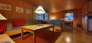 A wooden interior with a sofa, table, and chairs. - Sauna | Wi-Fi | Terrace | Wood stove | Cable TV (Lofsdalen)